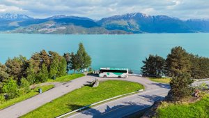 Buss fra Tide foran en innsjø og fjell i Norge