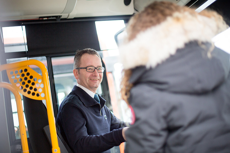 Smilende bussjåfør hos Tide Buss